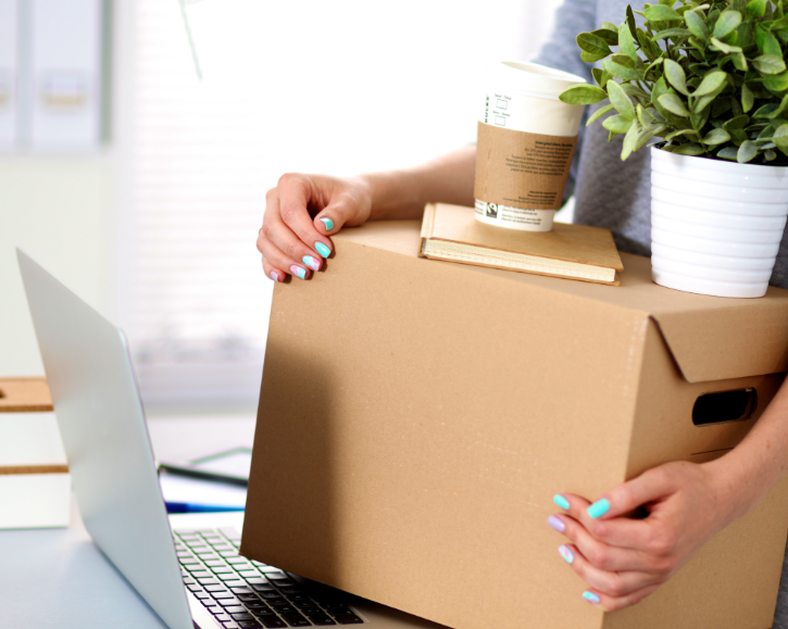 Lady holding a box, coffee and plant