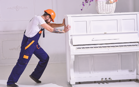 man trying to move piano